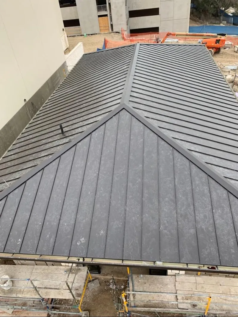 Commercial metal roof construction with crane equipment in Le Ray