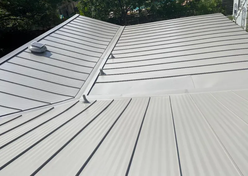 Solar attic fan installed on a metal roof for Roof Ventilation in Le Ray